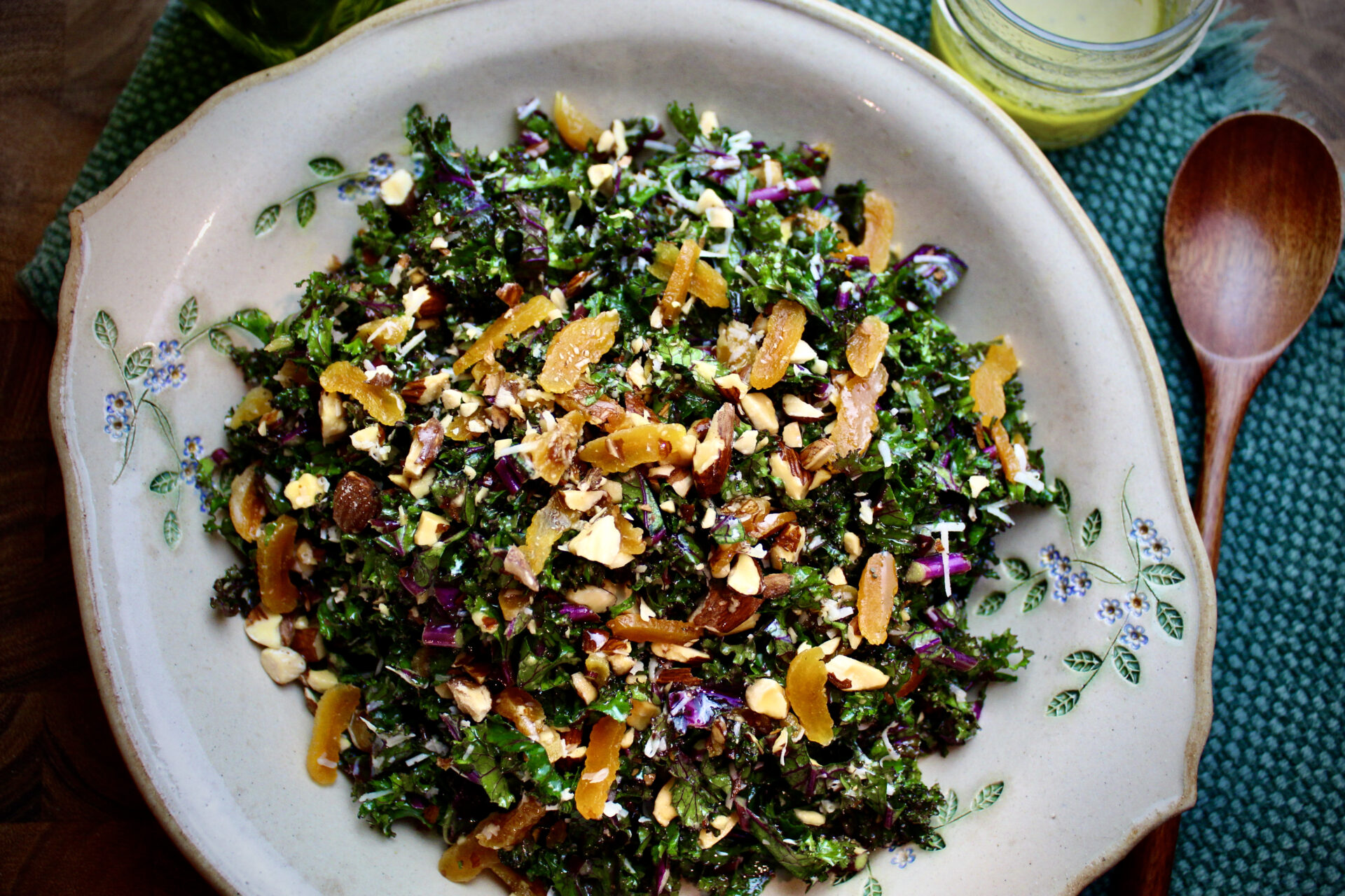 Learn how to make this tasty kale salad with dried apricots, almonds, and cheese. Dressed with a shallot vinaigrette.