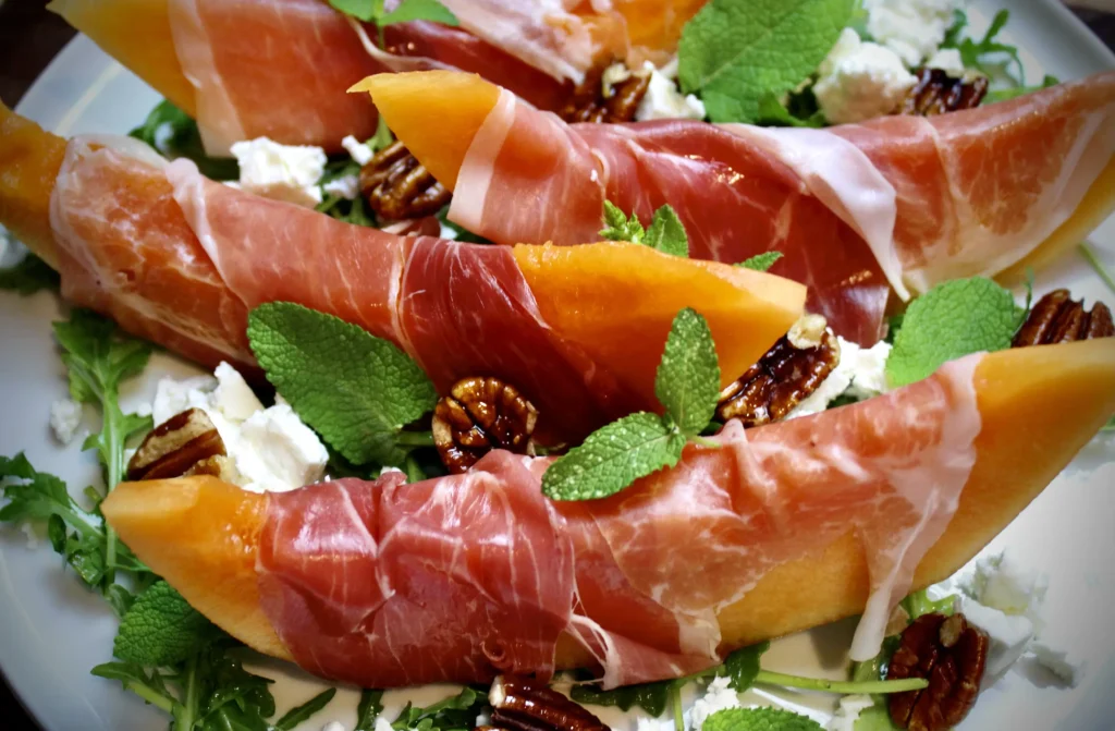 Melon and Prosciutto with candied pecans, mint, and feta cheese. Quick, simple, and surprisingly sooo delicious! 