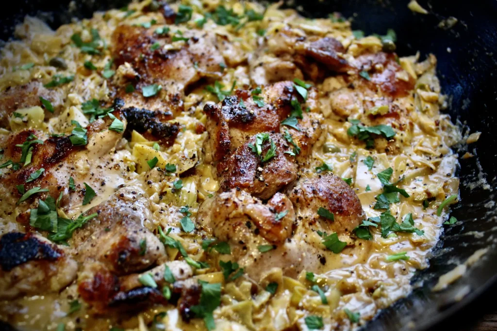 Skillet Chicken Thighs in a creamy, Parmesan-artichoke sauce. Quick, easy, and absolutely delicious!
