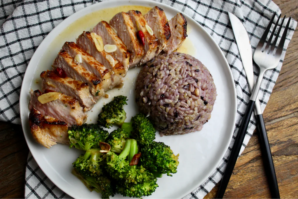 Perfectly cooked Vietnamese pork chops with multigrain rice and stir-fried broccoli. Pork chops flavored with a tangy, lime juice marinade. 
